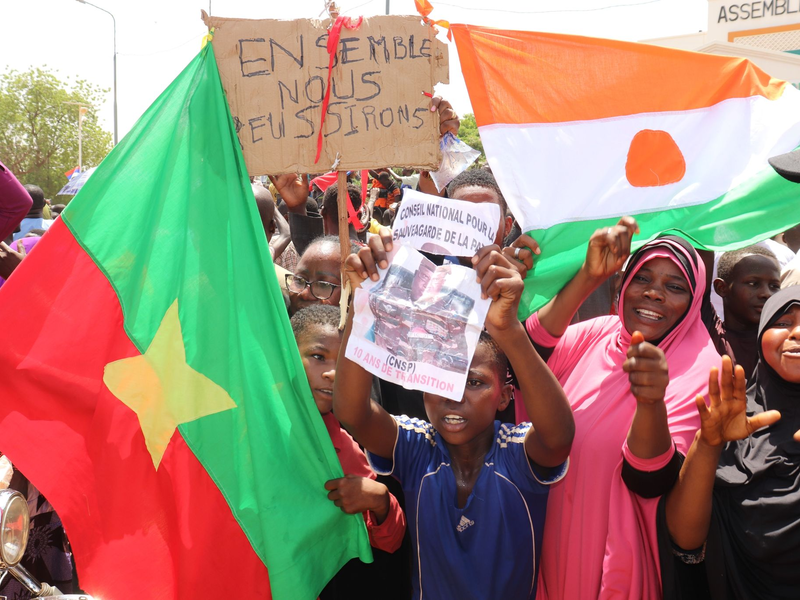 Befürworter des Putschs halten eine Flagge von Burkina Faso (l) und Niger hoch. Die beiden Länder haben einen Pakt geschlossen. - Foto: Djibo Issifou/dpa
