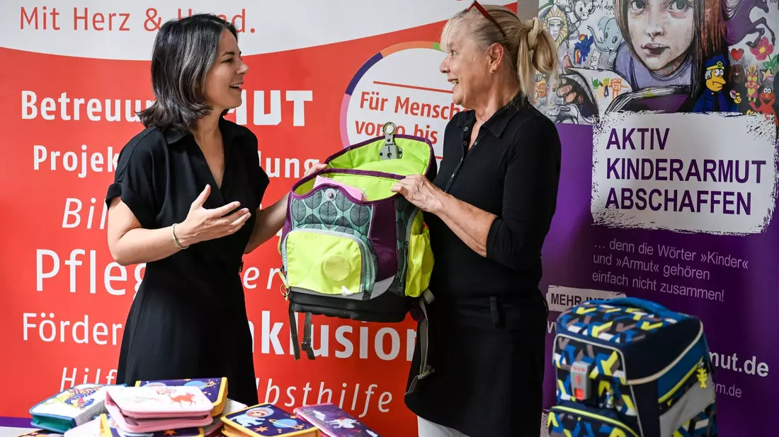 Außenministerin Annalena Baerbock (l, Bündnis 90/Die Grünen) und Angela Schweers, Vorstandvorsitzende AWO Potsdam, übergeben gesammelte Schulranzen an Kinder. - Bild: Jens Kalaene/dpa