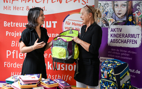 Außenministerin Annalena Baerbock (l, Bündnis 90/Die Grünen) und Angela Schweers, Vorstandvorsitzende AWO Potsdam, übergeben gesammelte Schulranzen an Kinder. - Foto: Jens Kalaene/dpa