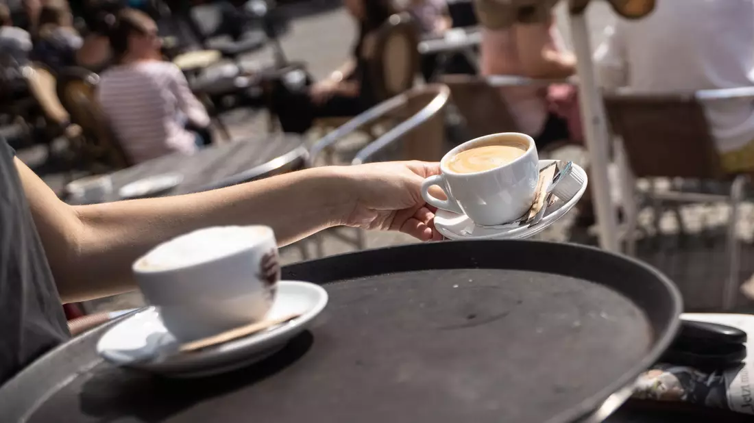Eine Studentin bedient am Vormittag in einem Cafe. Beim Fachkräftemangel in Hotels, Restaurants und Gaststätten ist derzeit keine Besserung in Sicht. - Bild: Frank Rumpenhorst/dpa