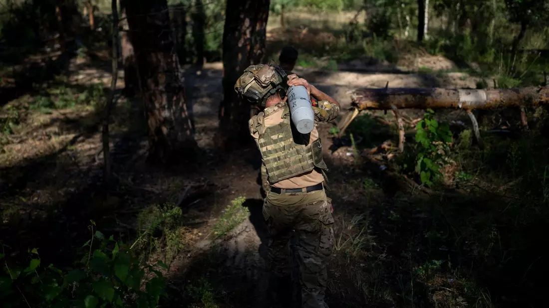 Ein ukrainischer Soldat trägt eine Granate an der Frontlinie in Lyman. - Bild: Bram Janssen/AP/dpa