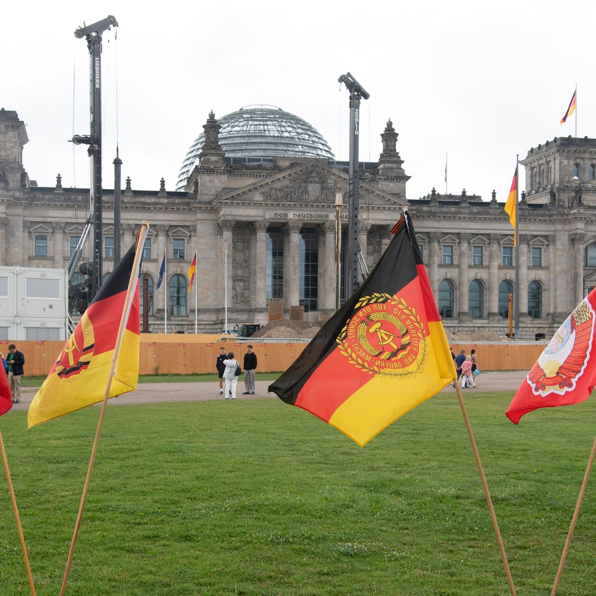 Jahrestag der Erstürmung des Reichstagsgebäudes: Fahnen stehen heute bei einer rechtsextremen Kundgebung vor dem Reichstagsgebäude. - Foto: Paul Zinken/dpa