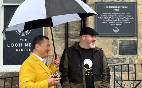 Paul Nixon (l) vom Loch Ness Centre und der Projektleiter Alan McKenna neben der Plakette, die an eine berühmte Nessie-Sichtung im Jahr 1933 erinnert. - Foto: Benedikt von Imhoff/dpa