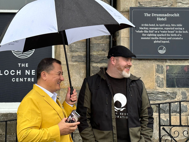 Paul Nixon (l) vom Loch Ness Centre und der Projektleiter Alan McKenna neben der Plakette, die an eine berühmte Nessie-Sichtung im Jahr 1933 erinnert. - Foto: Benedikt von Imhoff/dpa