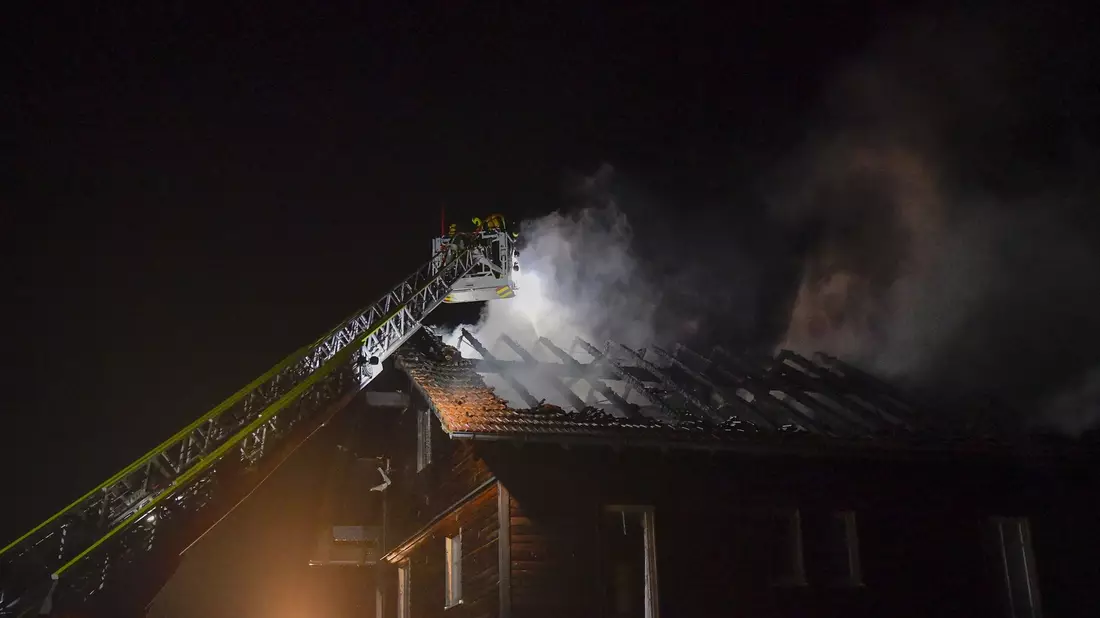 Die Feuerwehr löscht den Brand im Dachstuhl eines Hauses nach einem Blitzeinschlag. - Bild: Markus Zechbauer/zema-medien/dpa