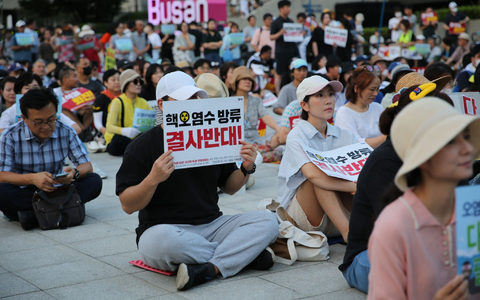 Auch im südkoreanischen Busan demonstrieren Menschen gegen die begonnene Einleitung aufbereiteten Kühlwassers aus der Atomruine Fukushima ins Meer. - Foto: Lu Rui/XinHua/dpa