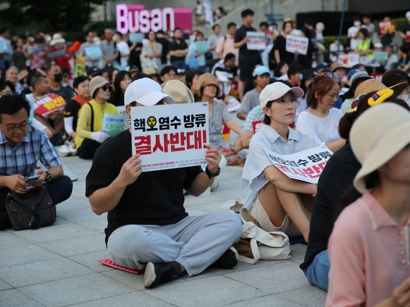 Auch im südkoreanischen Busan demonstrieren Menschen gegen die begonnene Einleitung aufbereiteten Kühlwassers aus der Atomruine Fukushima ins Meer. - Foto: Lu Rui/XinHua/dpa