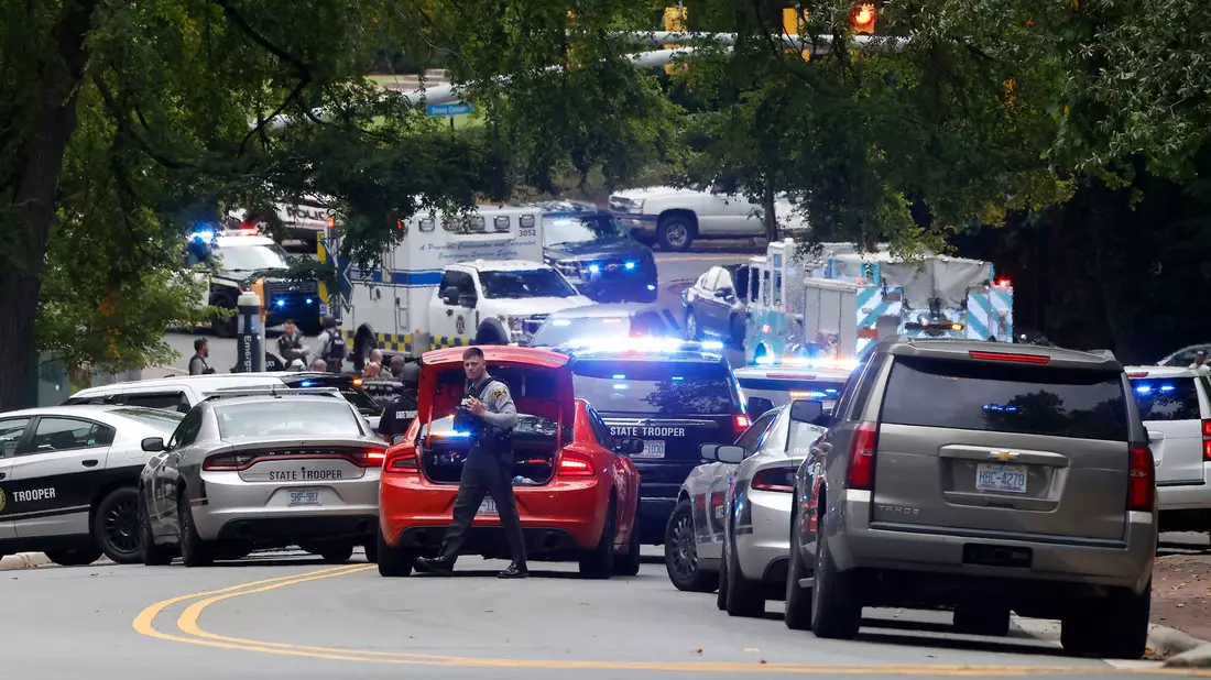Polizei und Ersthelfer versammeln sich nahe des Glockenturms auf dem Campus der University of North Carolina, nachdem eine «bewaffnete und gefährliche Person» gemeldet wurde. - Bild: Kaitlin McKeown/The News & Observer via AP/dpa