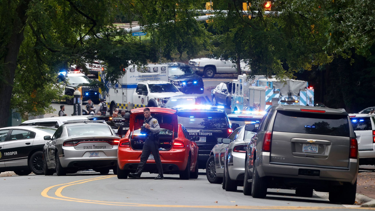 Polizei und Ersthelfer versammeln sich nahe des Glockenturms auf dem Campus der University of North Carolina, nachdem eine «bewaffnete und gefährliche Person» gemeldet wurde. - Foto: Kaitlin McKeown/The News & Observer via AP/dpa