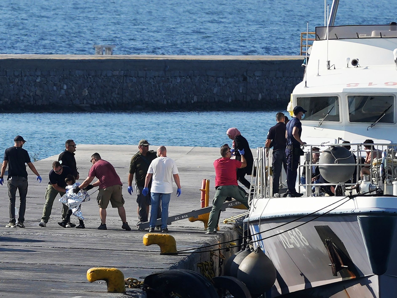 Menschen werden nach der Rettungsaktion im Hafen von Mytilini auf Lesbos von Beamten der Küstenwache eskortiert. - Foto: Panagiotis Balaskas/AP/dpa