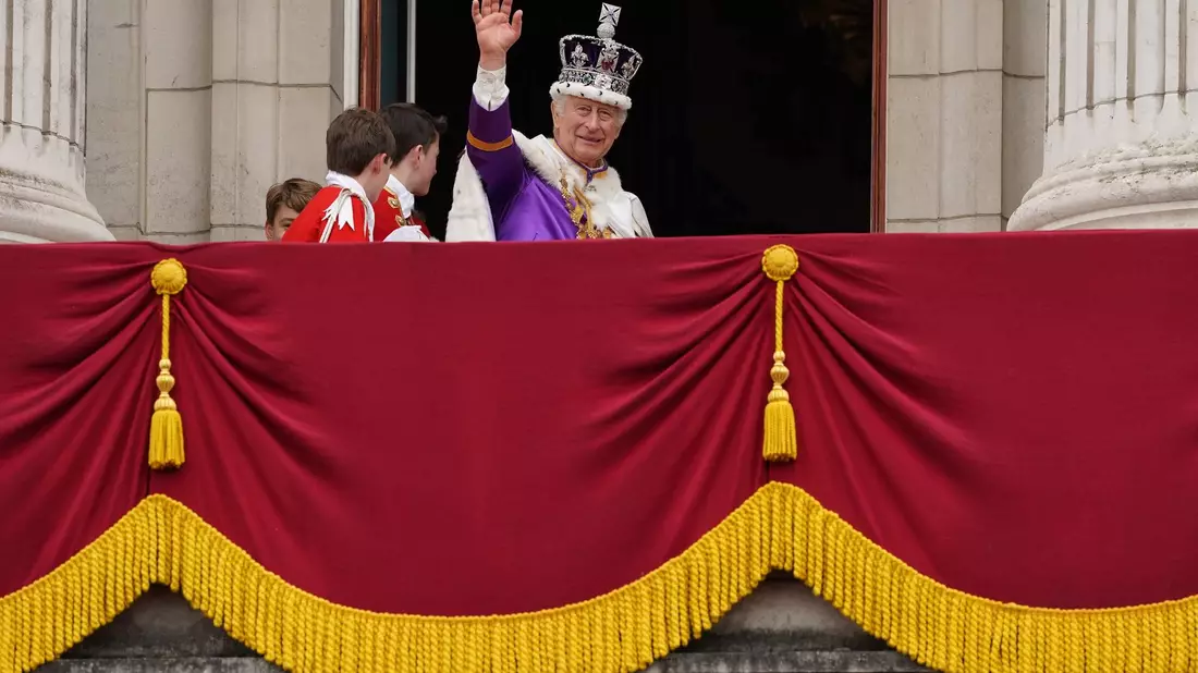König Charles III. winkt nach der Krönungszeremonie vom Balkon des Buckingham-Palastes. - Bild: Stefan Rousseau/PA Wire/dpa