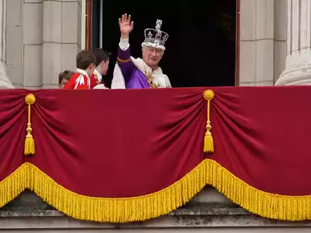 König Charles III. winkt nach der Krönungszeremonie vom Balkon des Buckingham-Palastes. - Foto: Stefan Rousseau/PA Wire/dpa