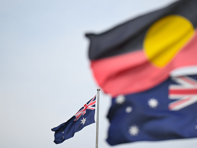 Zwei australische und eine Aborigine-Flagge wehen in Canberra. - Foto: Lukas Coch/AAP/dpa
