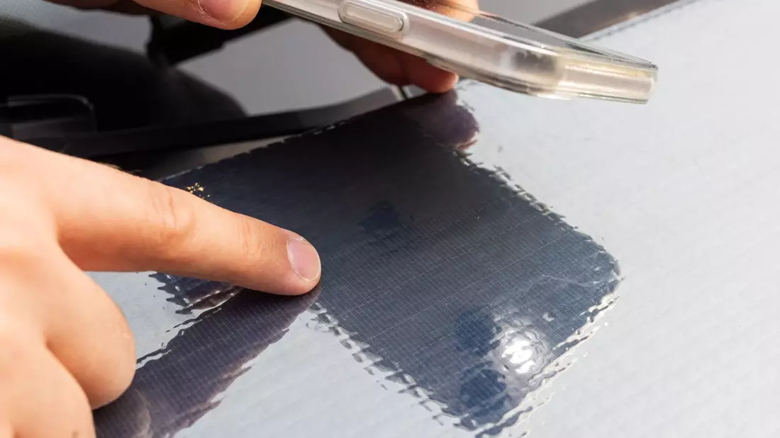 Ein Forscher des Fraunhofer ISE zeigt auf die Struktur der Solarzellen auf einer Motorhaube. - Bild: Philipp von Ditfurth/dpa