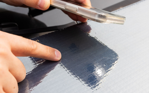 Ein Forscher des Fraunhofer ISE zeigt auf die Struktur der Solarzellen auf einer Motorhaube. - Foto: Philipp von Ditfurth/dpa