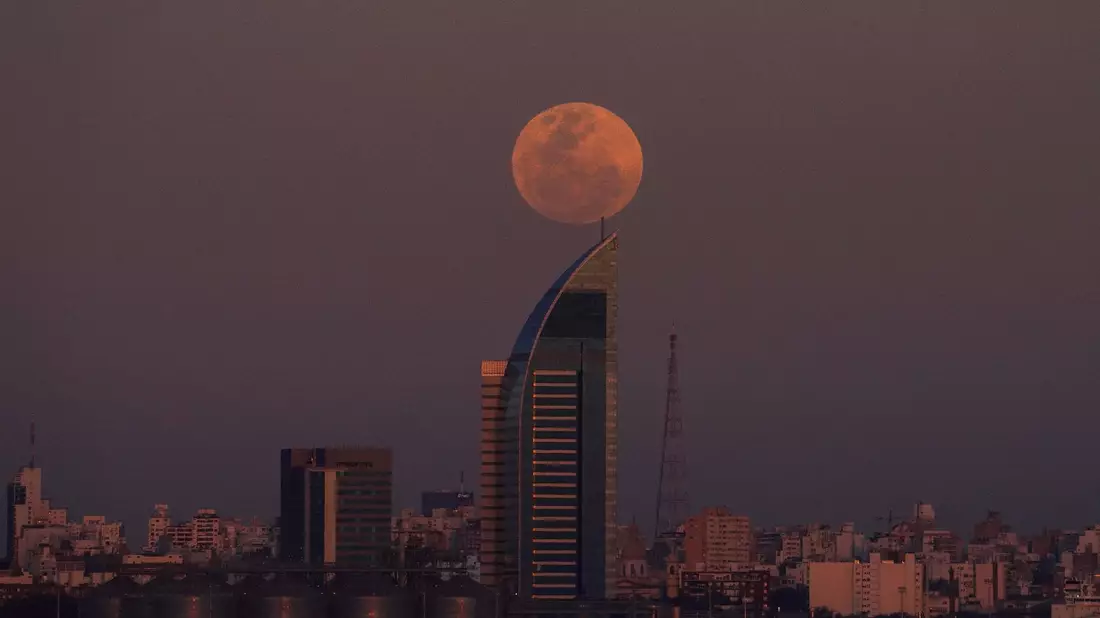 In rosa Licht getaucht geht der Vollmond über Montevideo in Uruguay auf. - Bild: Matilde Campodonico/AP