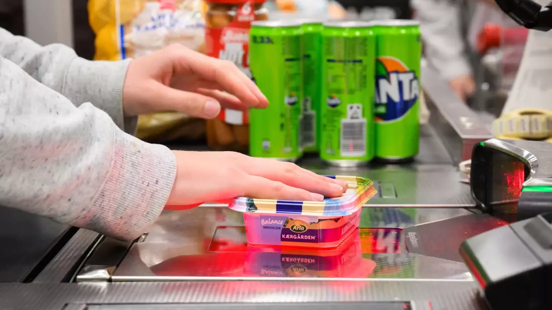 Eine Kassiererin scannt Lebensmittel an der Kasse eines Supermarktes. - Bild: Julian Stratenschulte/dpa