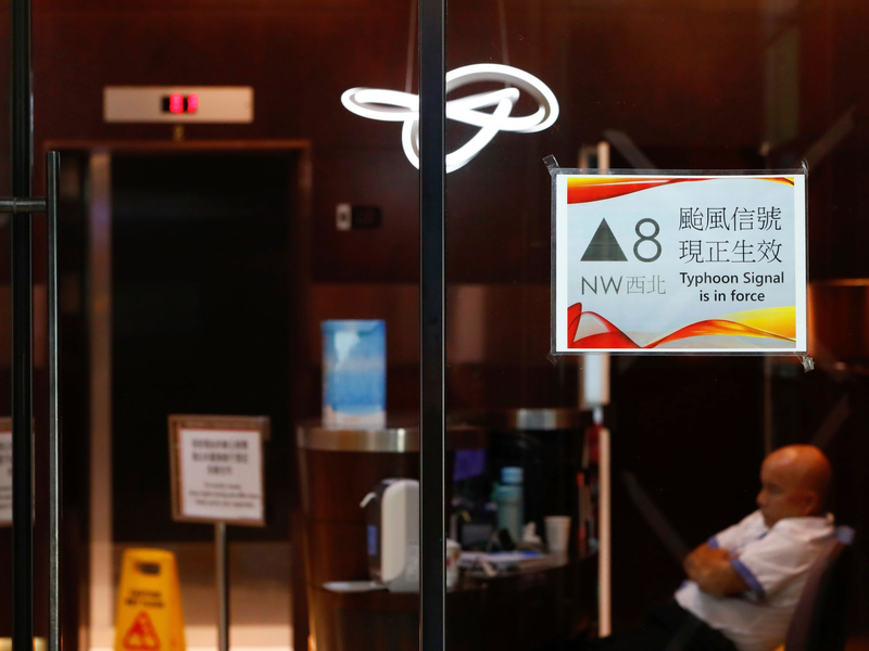 Menschen mit Regenschirmen kämpfen in Hongkong gegen starken Wind und Regen des Taifuns «Saola» an. - Foto: Daniel Ceng/AP/dpa
