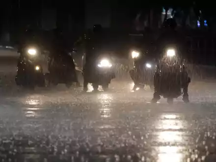 Rollerfahrer stehen bei heftigem Regen an einer Kreuzung in Taipeh. - Foto: Chiang Ying-ying/AP