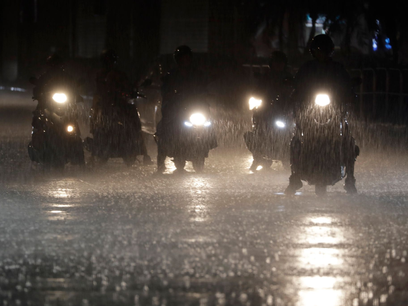 Rollerfahrer stehen bei heftigem Regen an einer Kreuzung in Taipeh. - Foto: Chiang Ying-ying/AP