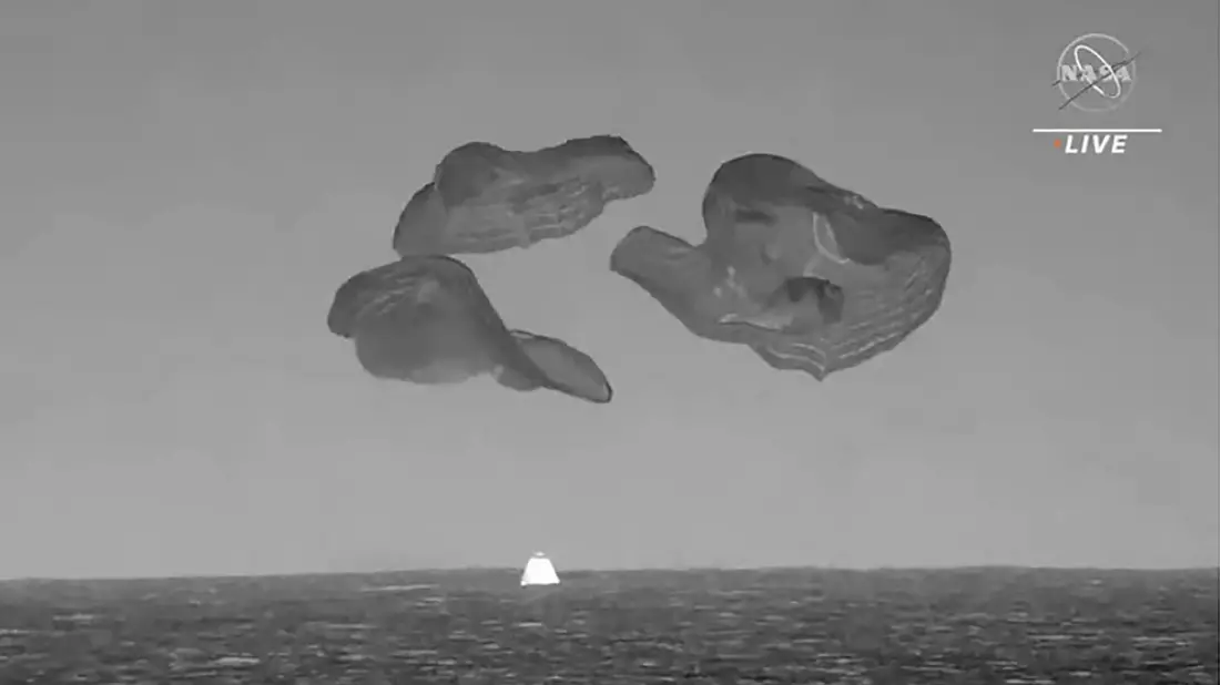 In diesem Bild aus einem von der NASA zur Verfügung gestellten Video taucht eine SpaceX-Kapsel, die von Fallschirmen gebremst wird,in den Atlantik vor der Küste Floridas ein. - Bild: NASA via AP