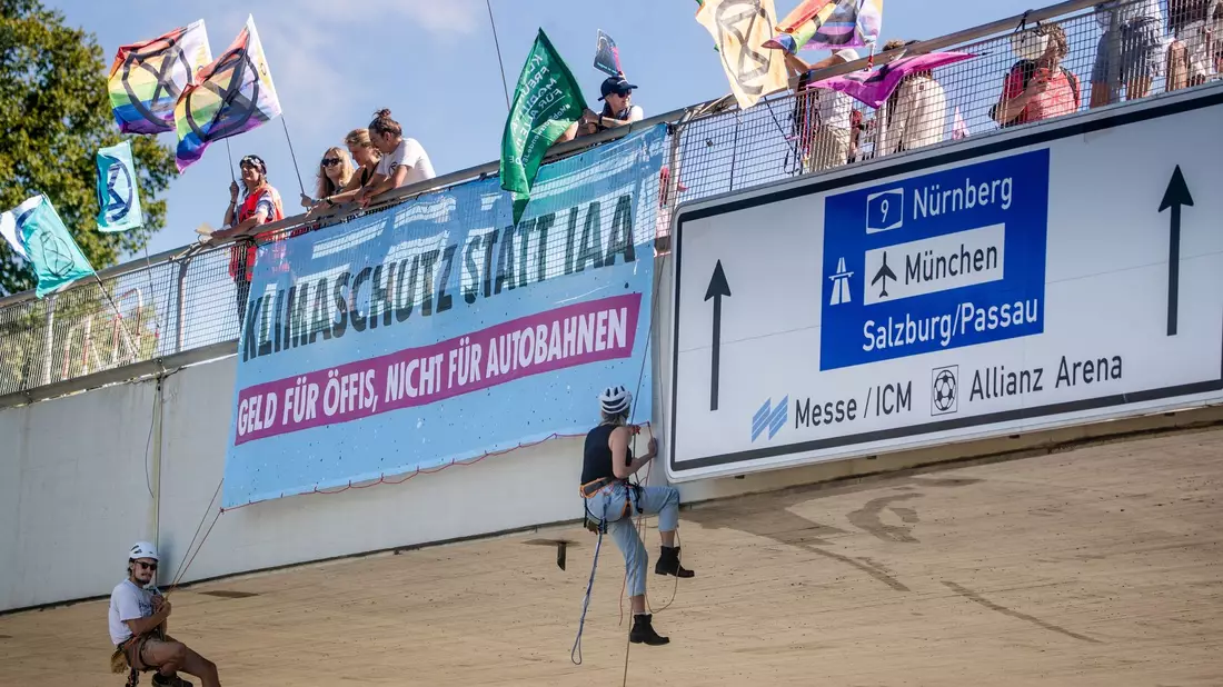 Klimaaktivisten von Extinction Rebellion  seilen sich in München von einer Brücke  ab. - Bild: Christoph Schmidt/dpa
