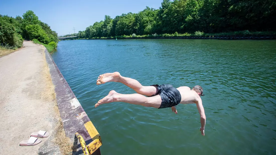 Ein junger Mann springt bei hochsommerlichem Wetter in den Rhein-Herne-Kanal. - Bild: Thomas Banneyer/dpa