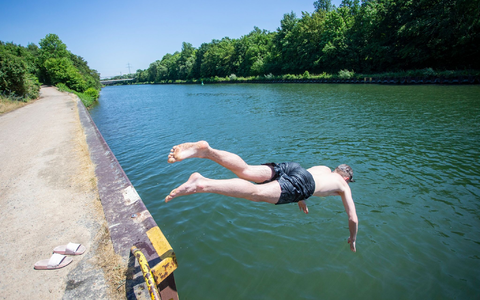 Ein junger Mann springt bei hochsommerlichem Wetter in den Rhein-Herne-Kanal. - Foto: Thomas Banneyer/dpa