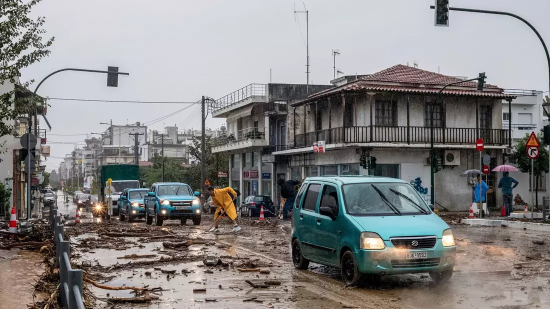 Ein Mann säubert die Straße nach dem Hochwasser in Volos. - Bild: Anastasia Karekla/Eurokinissi/AP/dpa