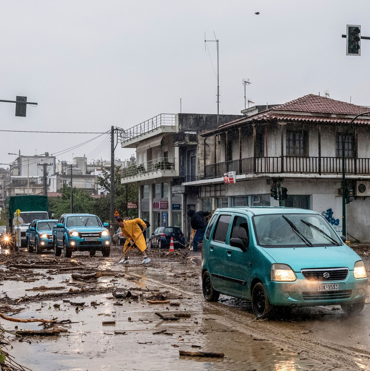 Ein Mann säubert die Straße nach dem Hochwasser in Volos. - Foto: Anastasia Karekla/Eurokinissi/AP/dpa