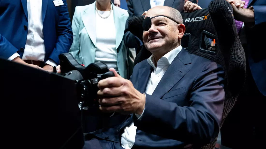 Der Bundeskanzler steuert: Olaf Scholz auf der IAA in einem Autosimulator. - Bild: Sven Hoppe/dpa POOL/dpa
