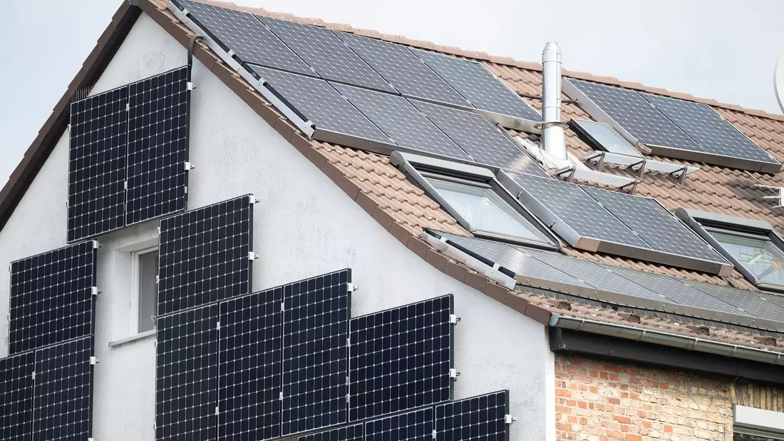 Solarpanele sind an der Fassade und auf dem Dach eines Hauses in Frankfurt befestigt. - Bild: Sebastian Gollnow/dpa