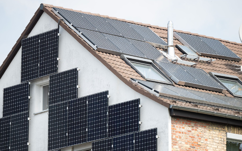 Solarpanele sind an der Fassade und auf dem Dach eines Hauses in Frankfurt befestigt. - Foto: Sebastian Gollnow/dpa