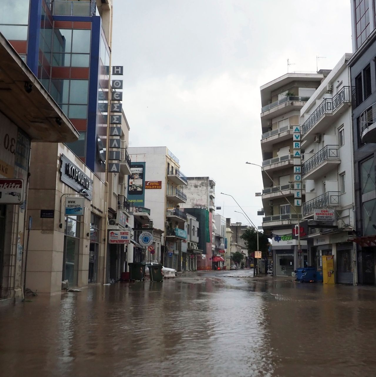 Feuerwehrleute verwenden Seile, um einen Nierenpatienten auf einer Trage über eine durch einen Regensturm beschädigte Straße zu transportieren. - Foto: Thodoris Nikolaou/AP/dpa