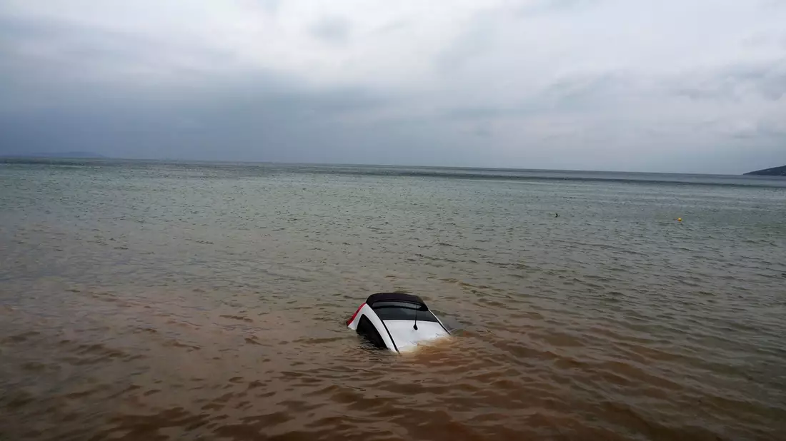 Ein Auto ist nach einem Rekordregen in Milina fast ganz im Meer versunken. - Bild: Thodoris Nikolaou/AP/dpa