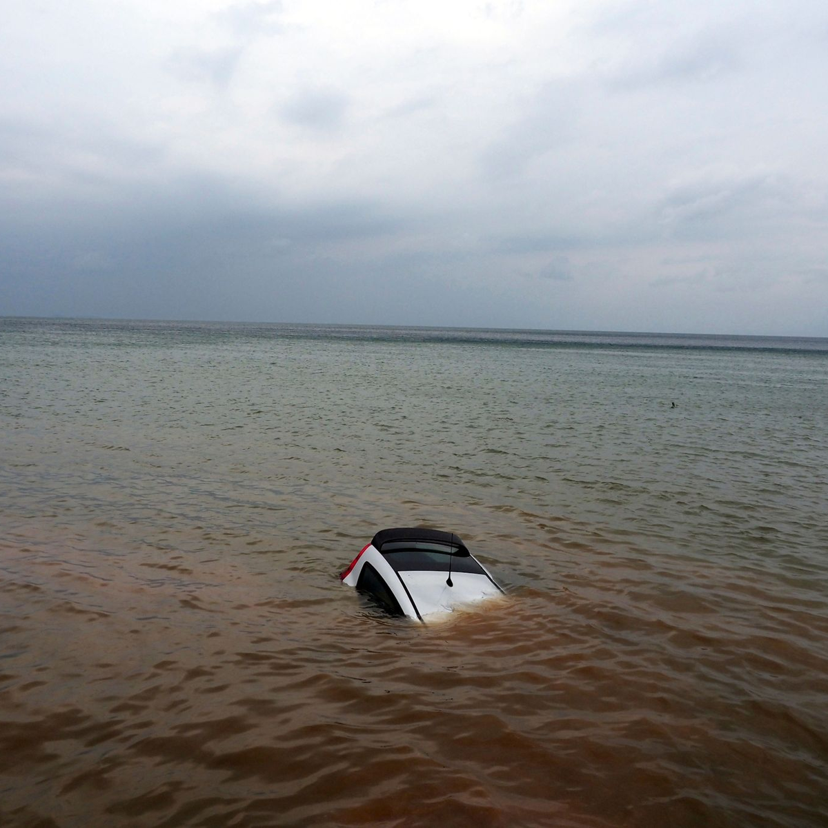 Ein Auto ist nach einem Rekordregen in Milina fast ganz im Meer versunken. - Foto: Thodoris Nikolaou/AP/dpa