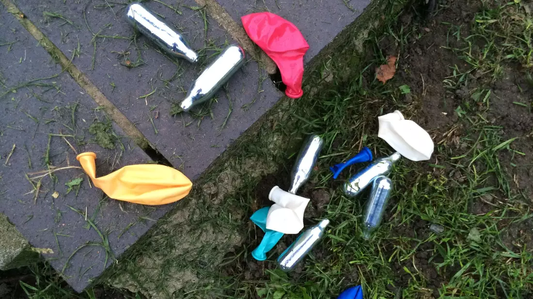 Lachgas-Kartuschen und Luftballons in einem Park in London. Die britische Regierung will den Konsum von Lachgas eindämmen. - Bild: Teresa Dapp/dpa