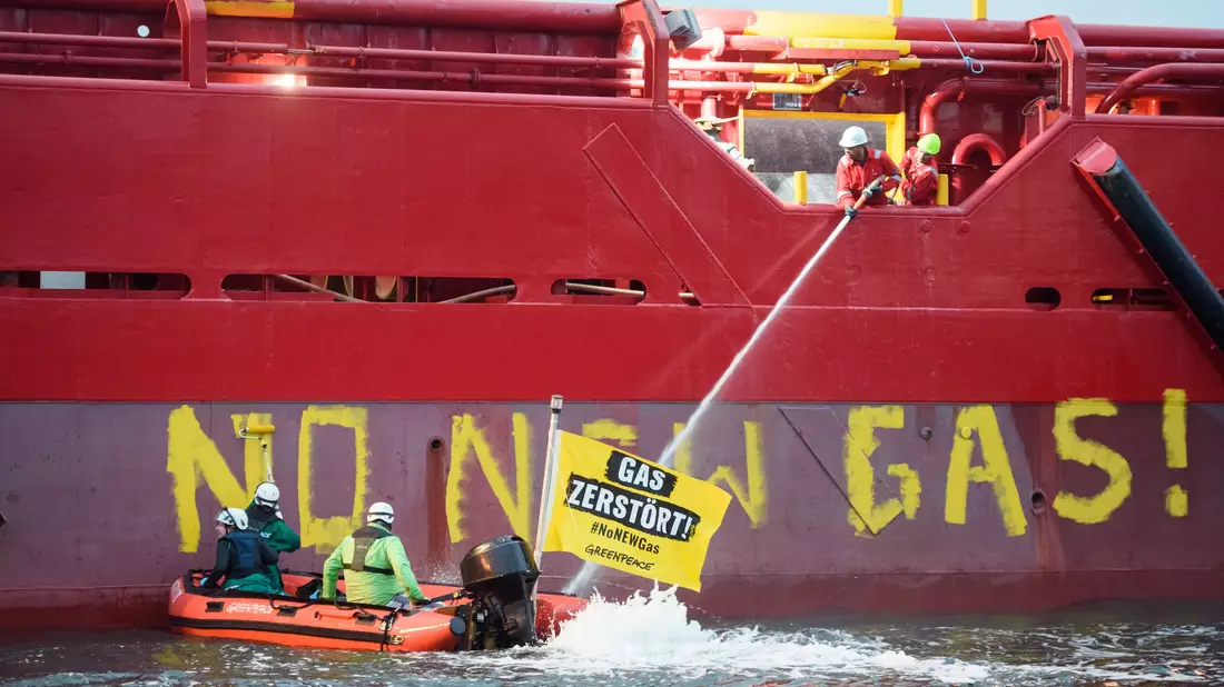 Greenpeace-Aktivisten liegen mit einem Schlauchboot vor einem Schiff im Hafen von Mukran. - Bild: Gregor Fischer/Greenpeace Germany/dpa