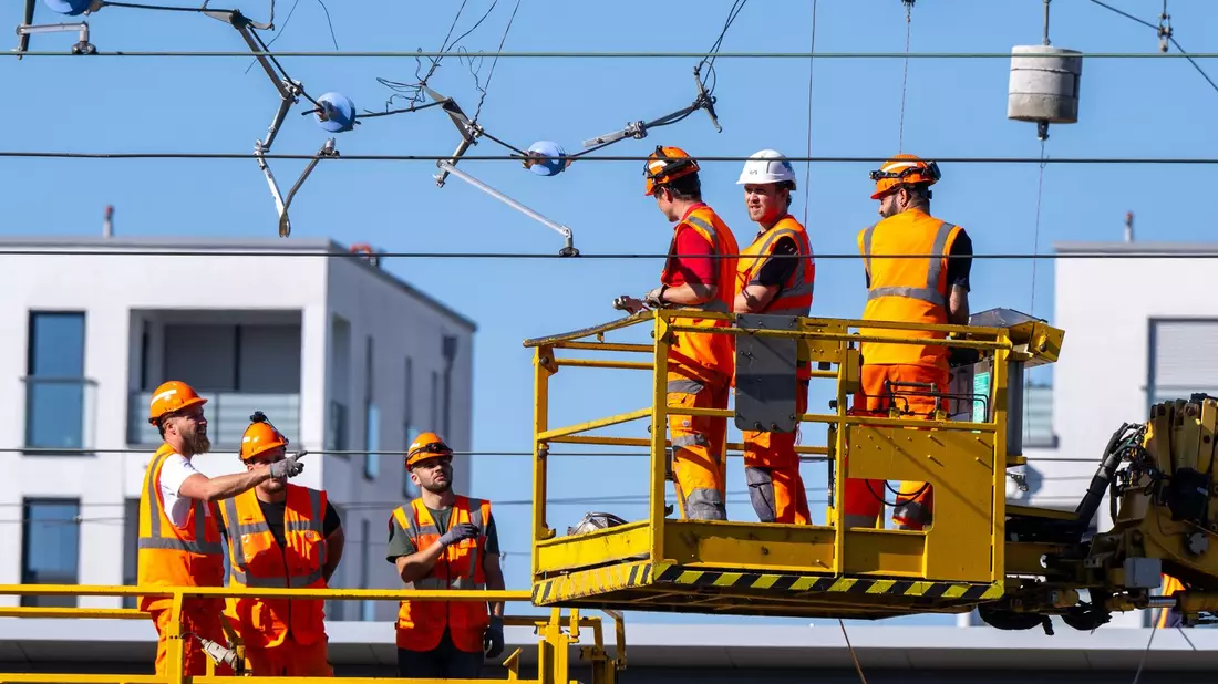 Arbeiter reparieren in München eine abgerissene Oberleitung. - Bild: Lennart Preiss/dpa