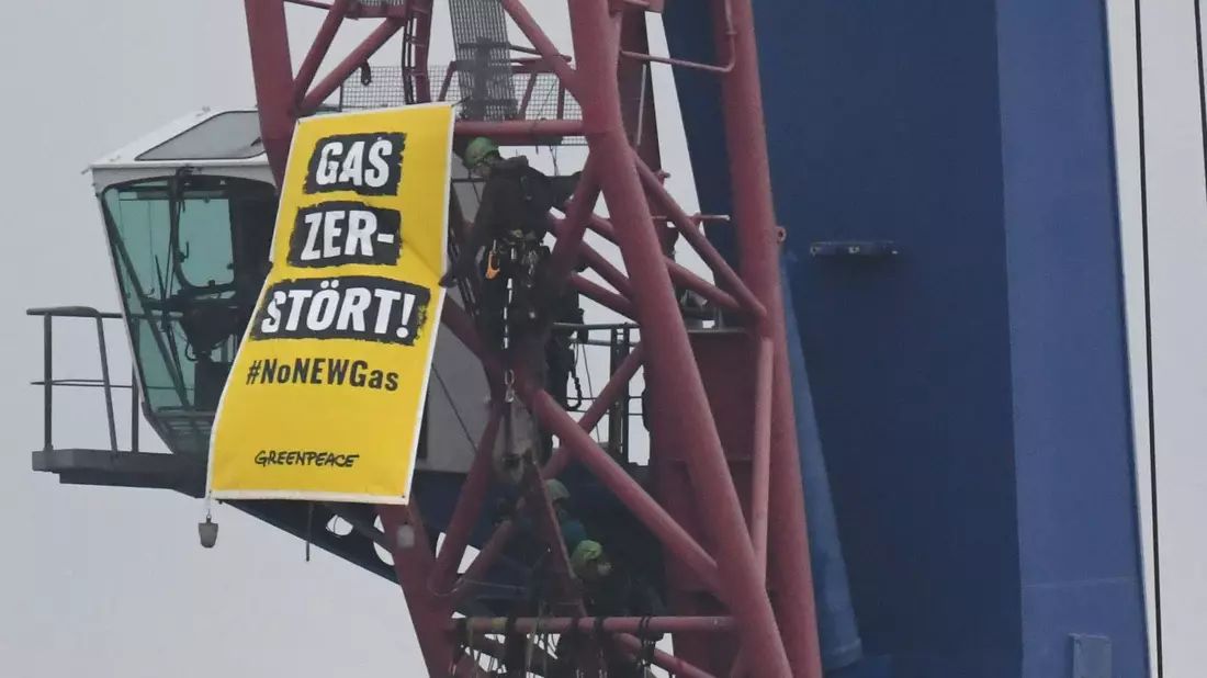 Greenpeace-Aktivisten protestieren auf einem Kran gegen den Start der Verlegung einer Gas-Pipeline im Hafen von Mukran im Norden der Insel Rügen. - Bild: Stefan Sauer/dpa