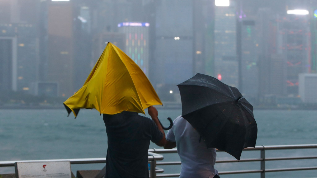 Menschen mit Regenschirmen kämpfen in Hongkong mit starkem Wind und Regen des Taifuns «Saola». - Foto: Daniel Ceng/AP/dpa