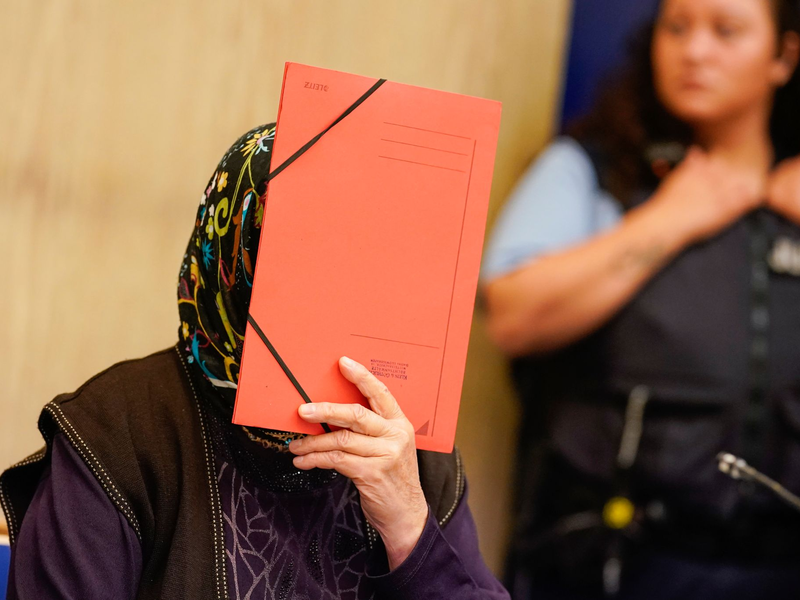 Die Angeklagte verbirgt ihr Gesicht im Verhandlungssaal des Landgerichts Mannheim. - Foto: Uwe Anspach/dpa