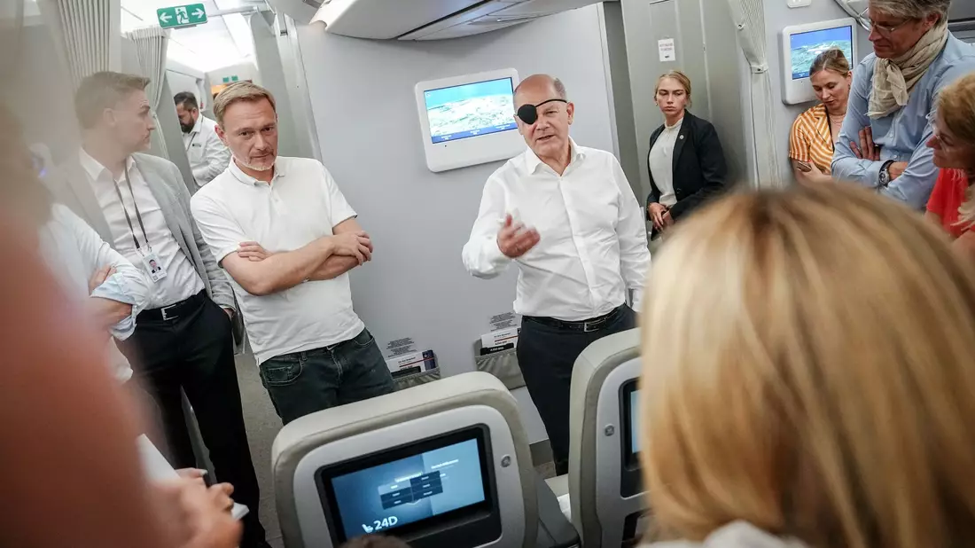 Bundeskanzler Olaf Scholz (r, SPD) und Finanzminister Christian Lindner (FDP) sprechen auf dem Flug nach Neu Dehli mit Journalisten. - Bild: Kay Nietfeld/dpa