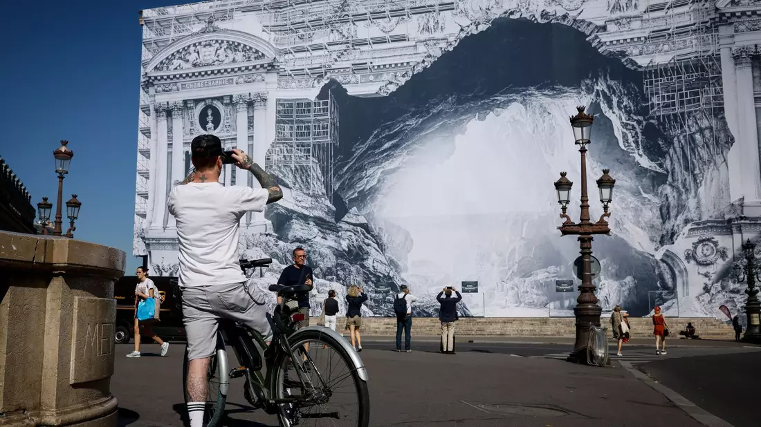 Ein Fahrradfahrer ist vor der verzierten Opera Garnier in Paris unterwegs. - Bild: Thomas Padilla/AP/dpa