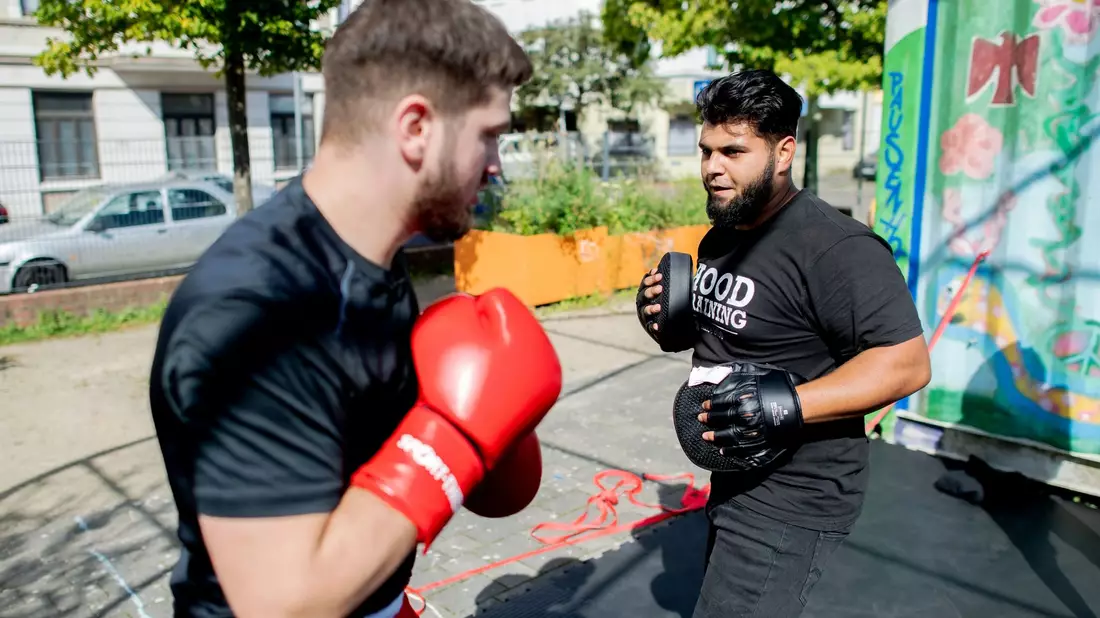 Aytac Alsancak (r.), und Oguzhan Demir, beide Boxtrainer im sogenannten Hood Training, auf dem Quartiersplatz Leher Pausenhof im Stadtteil Lehe. - Bild: Hauke-Christian Dittrich/dpa