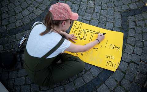 Eine junge Frau schreibt auf ein Schild: «Harry, I came all the way to take a photo with you!» - Foto: Fabian Strauch/dpa Eine junge Frau schreibt auf ein Schild: «Harry, I came all the way to take a photo with you!» - Foto: Fabian Strauch/dpa