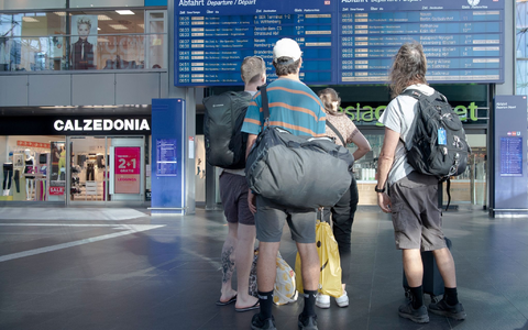 Reisende im Berliner Hauptbahnhof vor einer Info-Tafel mit Zugverbindungen. - Foto: Paul Zinken/dpa