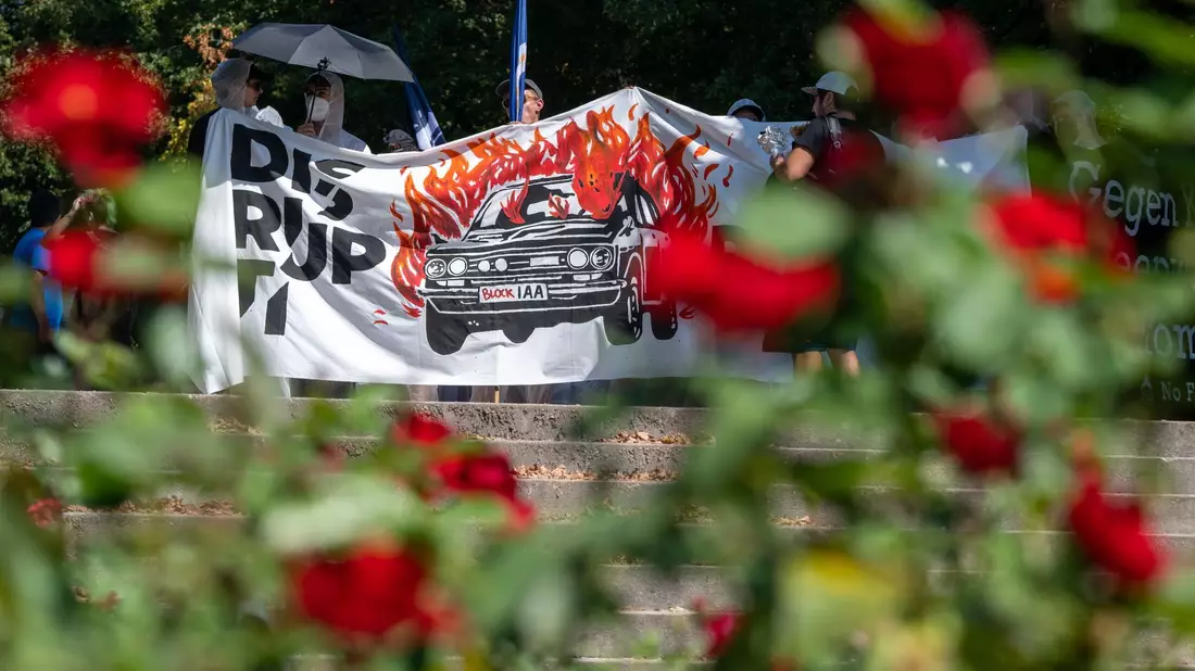 Aktivisten halten ein Banner bei der Abschlussdemonstration gegen die Automesse IAA MOBILITY 2023. - Bild: Stefan Puchner/dpa