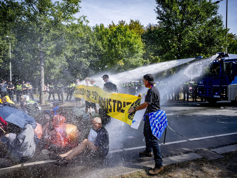 Einsatz von Wasserwerfern gegen Klimaaktivisten, die eine Straße blockieren. - Foto: Robin Utrecht/ANP/dpa