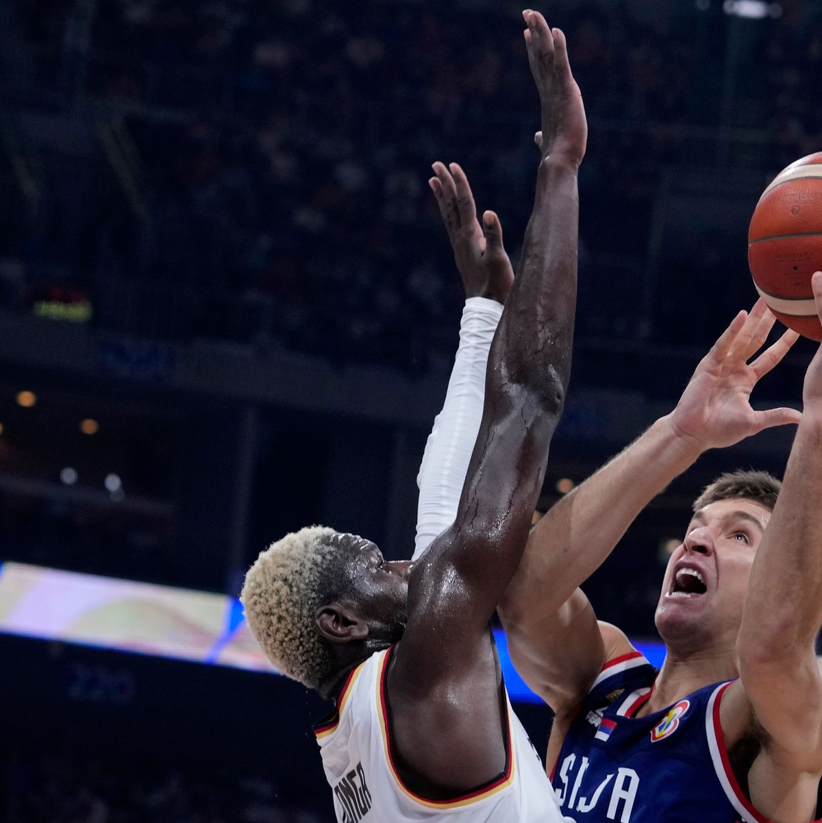 Enge Duelle am Korb: Isaac Bonga (l) aus Deutschland wehrte ein ums andere Mal serbische Angriffe ab. - Foto: Michael Conroy/AP/dpa